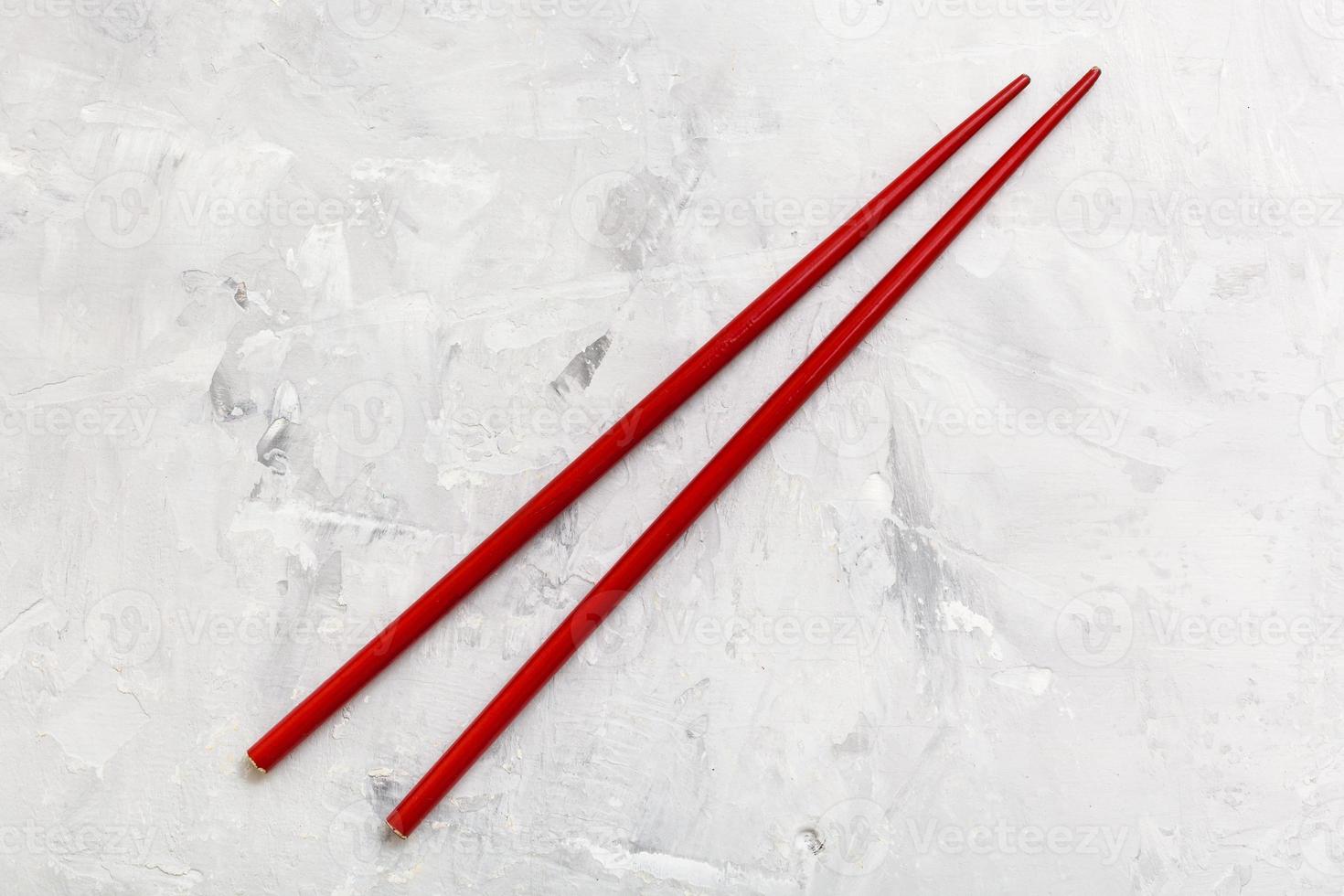 red wooden chopsticks on concrete board photo