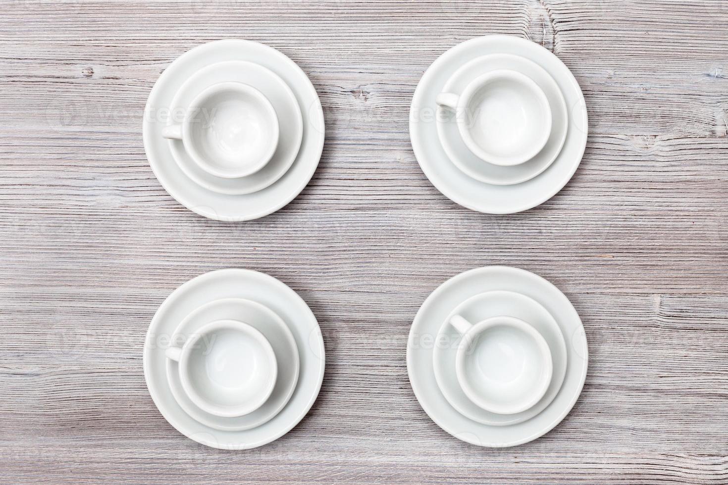 top view of four cups and saucers on gray table photo