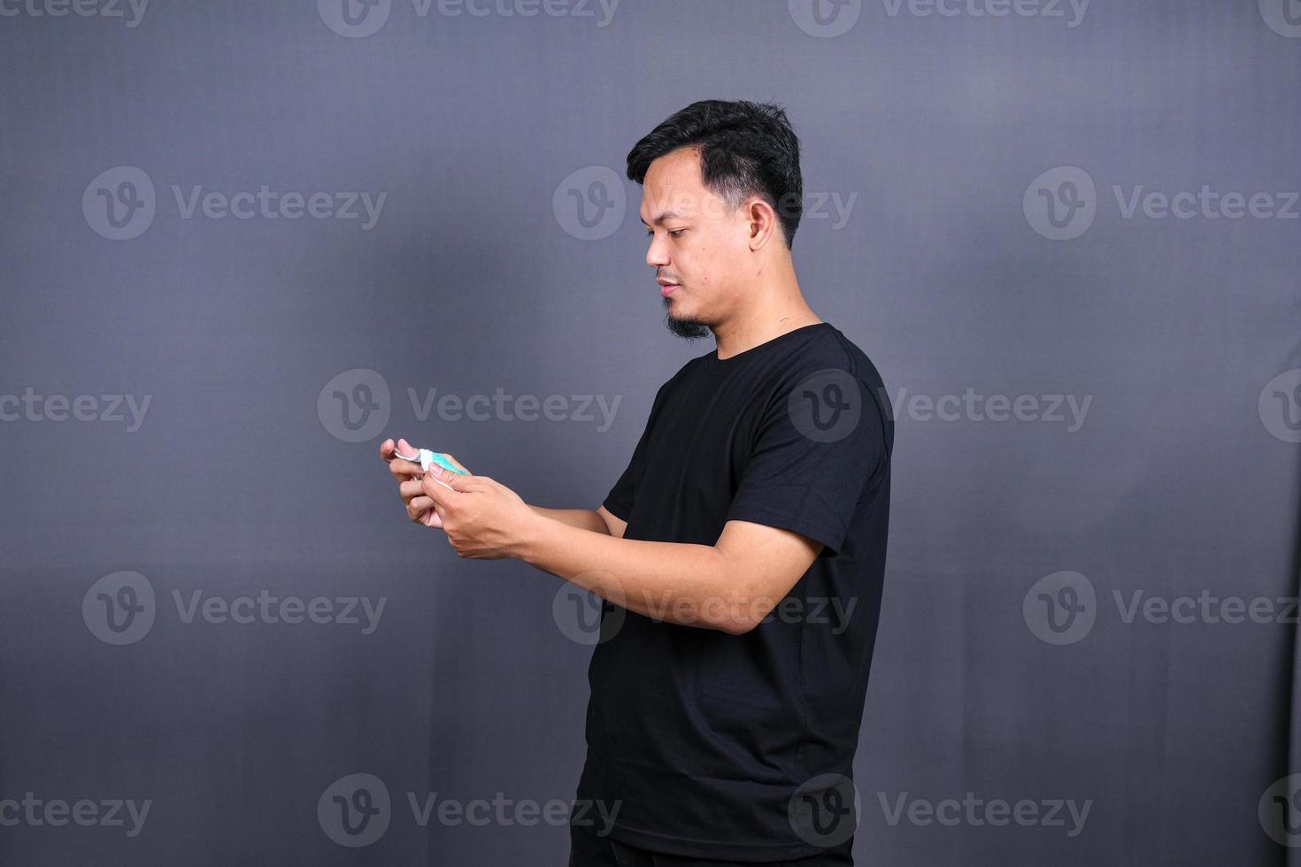 Asian man take off masks as the pandemic is over. Isolated on a Gray Background photo