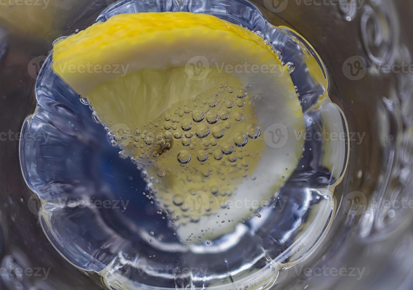 a slice of lemon dipped in sparkling water. close up photo