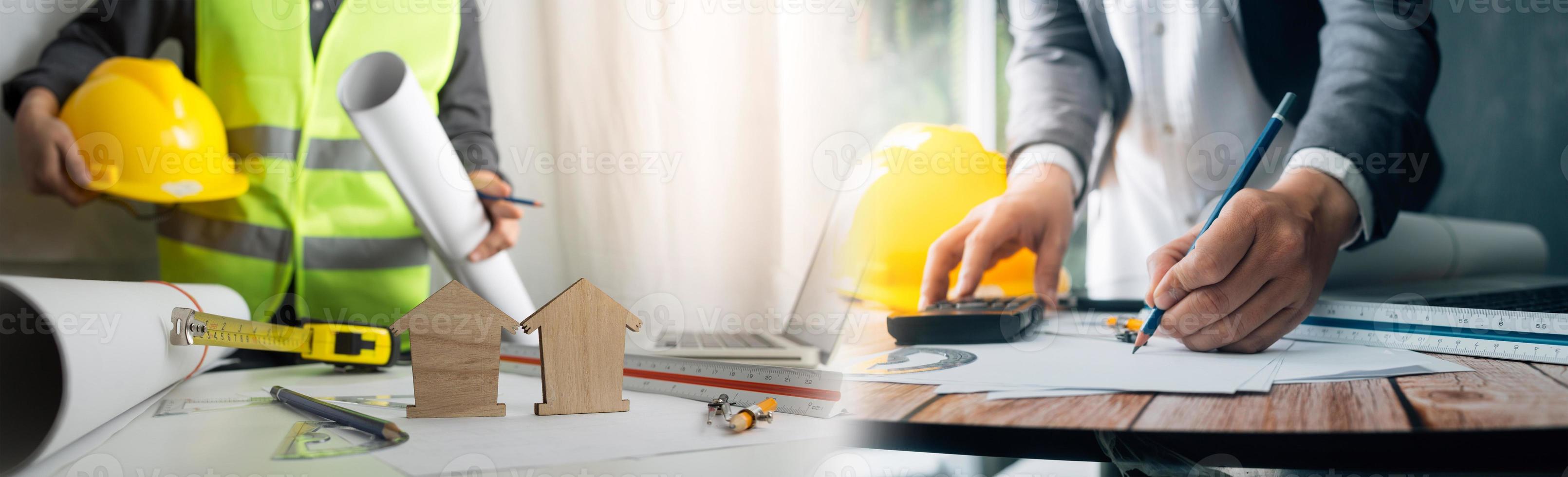 Two colleagues discussing data working and tablet, laptop with on on architectural project at construction site at desk in office photo