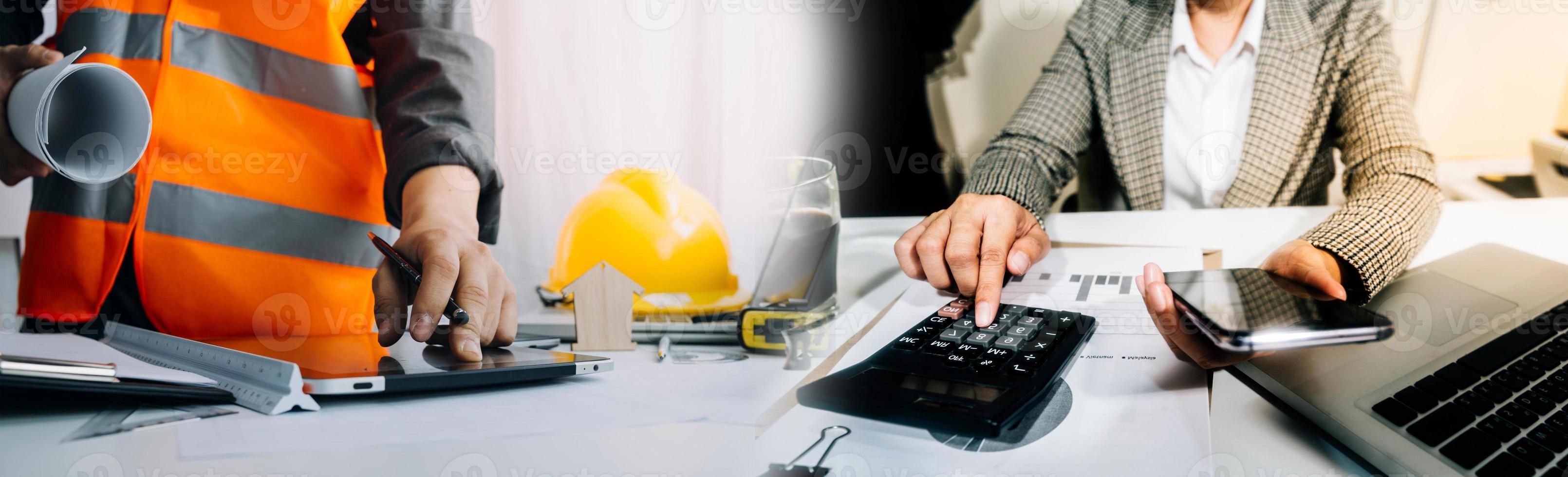 Two colleagues discussing data working and tablet, laptop with on on architectural project at construction site at desk in office photo