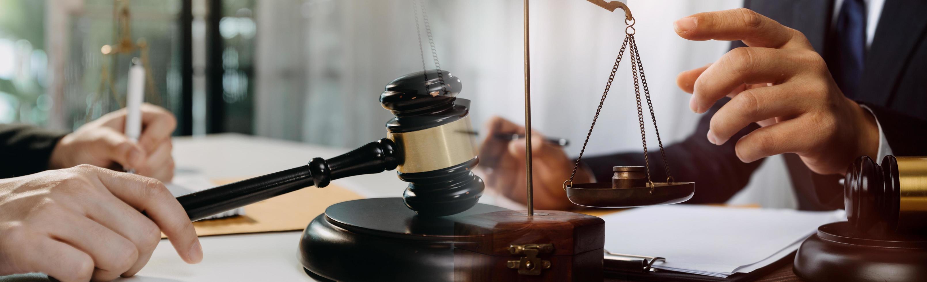 Business and lawyers discussing contract papers with brass scale on desk in office. Law, legal services, advice, justice and law concept picture with film grain effect photo