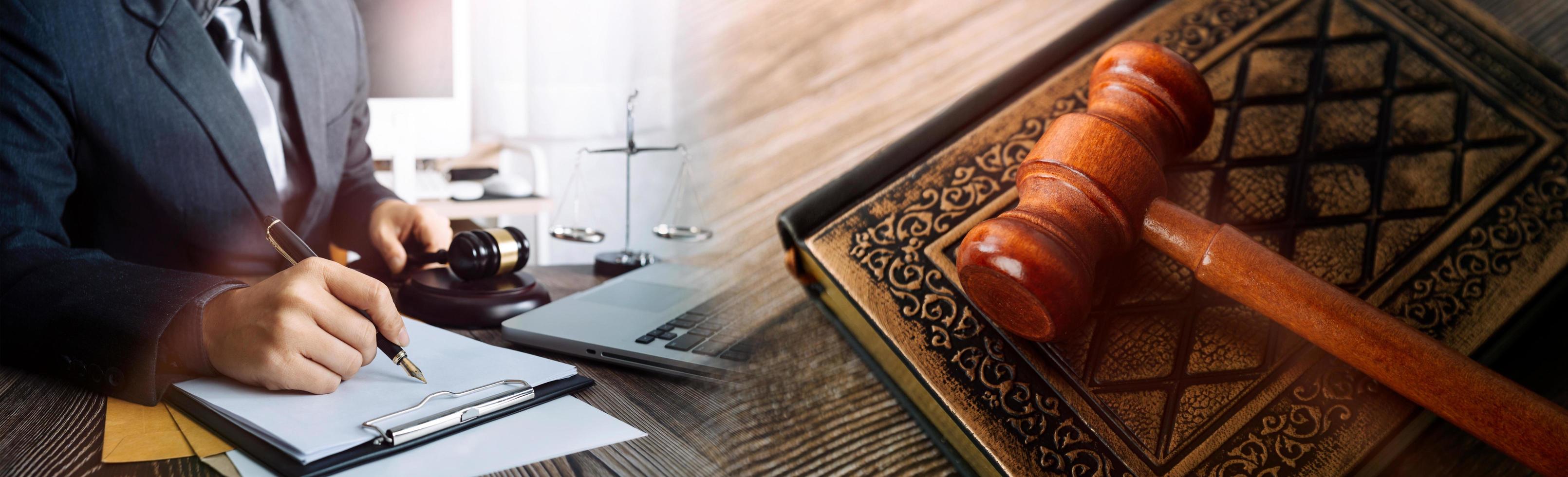 Justice and law concept.Male judge in a courtroom with the gavel, working with, computer and docking keyboard, eyeglasses, on table in morning light photo