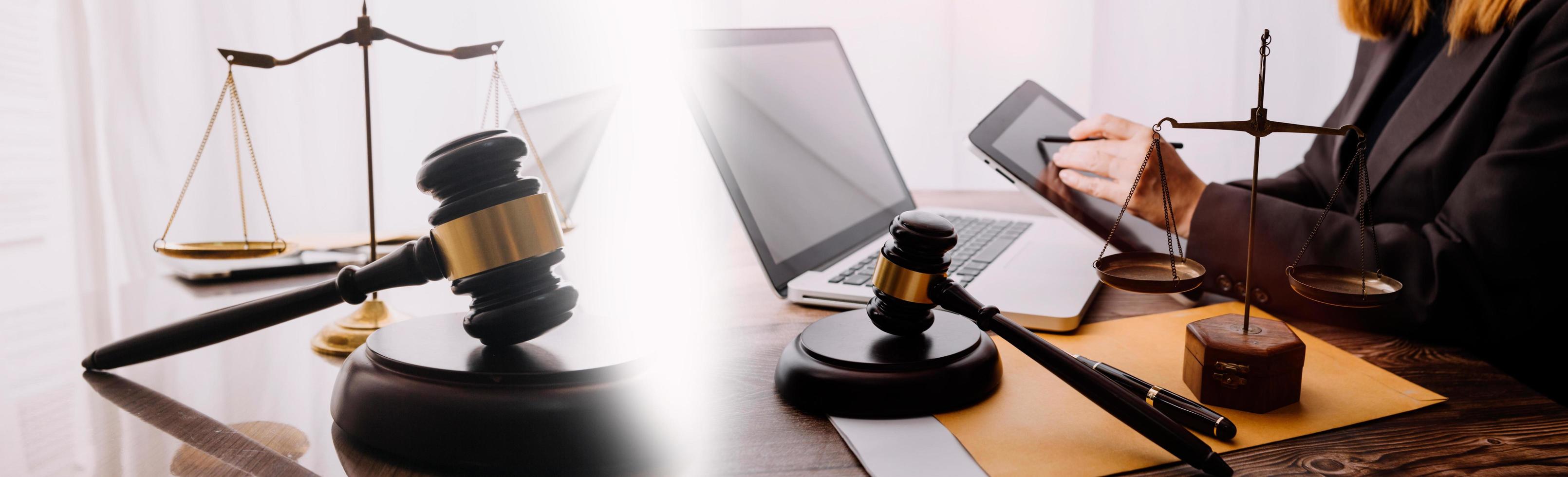 Justice and law concept.Male judge in a courtroom with the gavel, working with, computer and docking keyboard, eyeglasses, on table in morning light photo