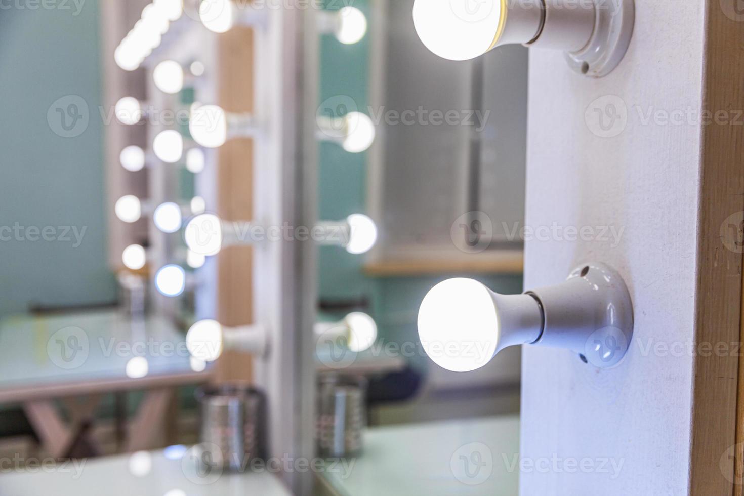 Empty woman makeup place with mirror and bulbs. Workplace makeup artist in modern makeup room. Barbershop interior. Dressing room with makeup mirror and table. Modern classical style interior design. photo