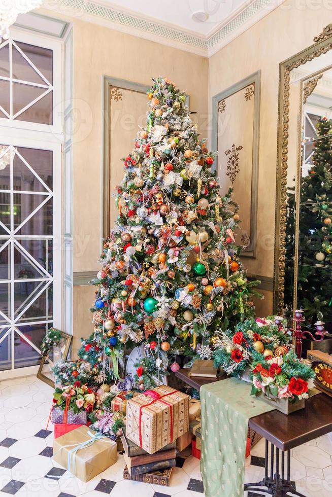 clásico navidad año nuevo decorado habitación interior árbol de año nuevo con adornos plateados y rojos foto