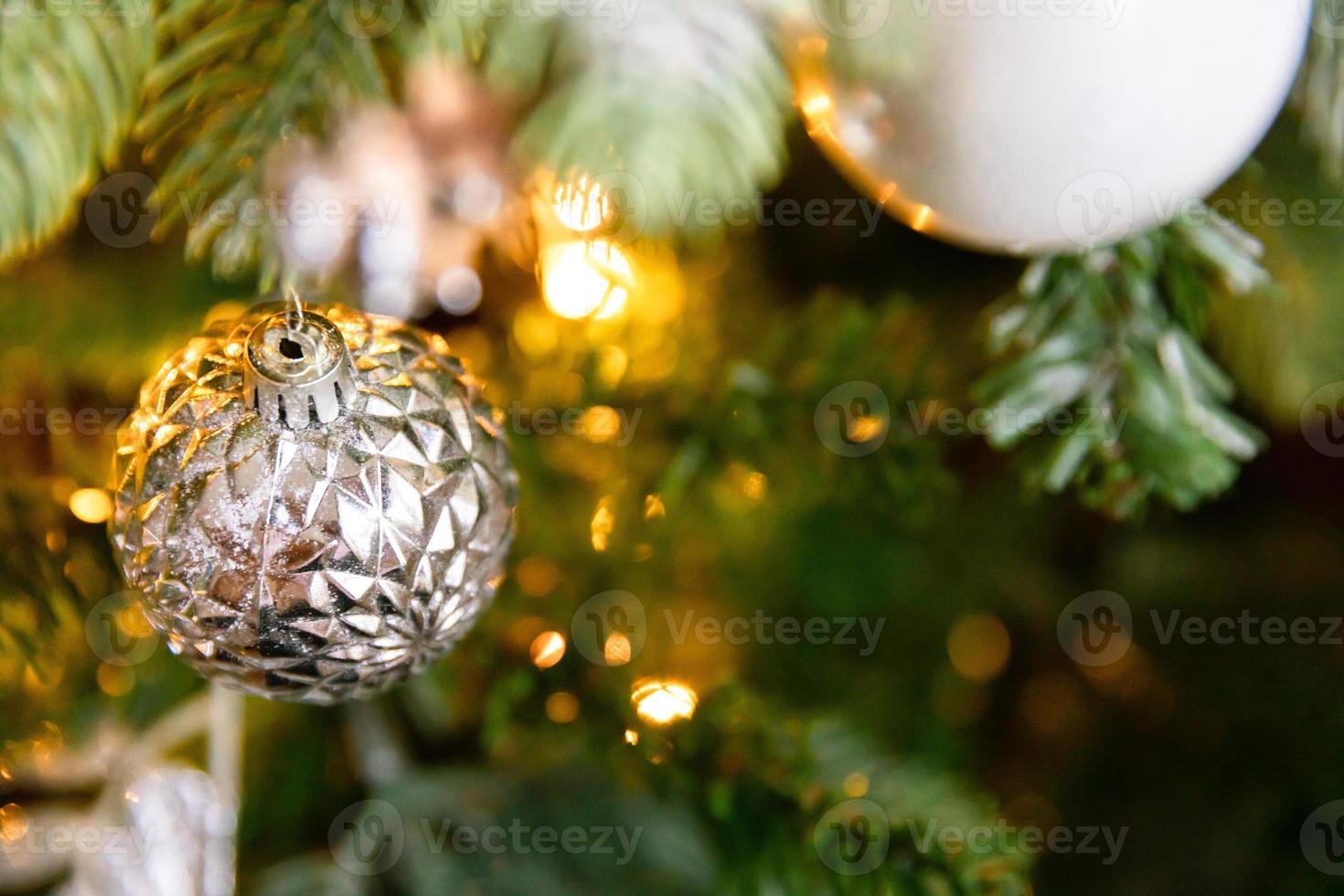 Classic Christmas decorated New year tree. Christmas tree with white and silver decorations, ornaments toy and ball. Modern classical style interior design apartment. Christmas eve at home. photo