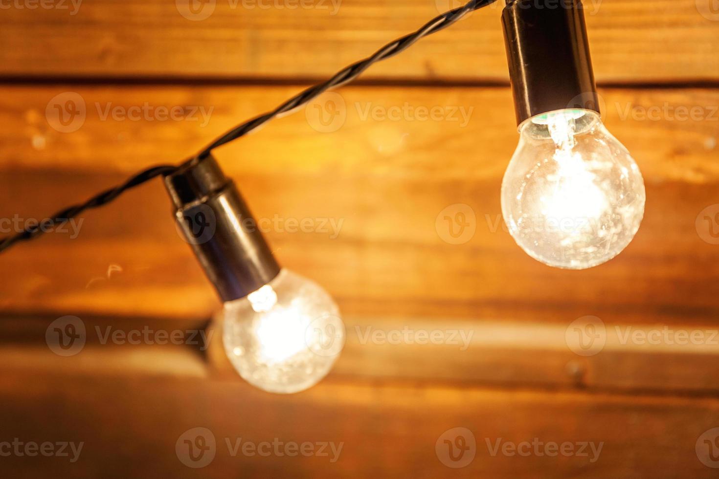 Modern dark classical style interior design apartment with retro lamps hanging light bulbs background. Wooden planks with lamps. Decorated interior room with gold lights. Copy space mockup poster. photo