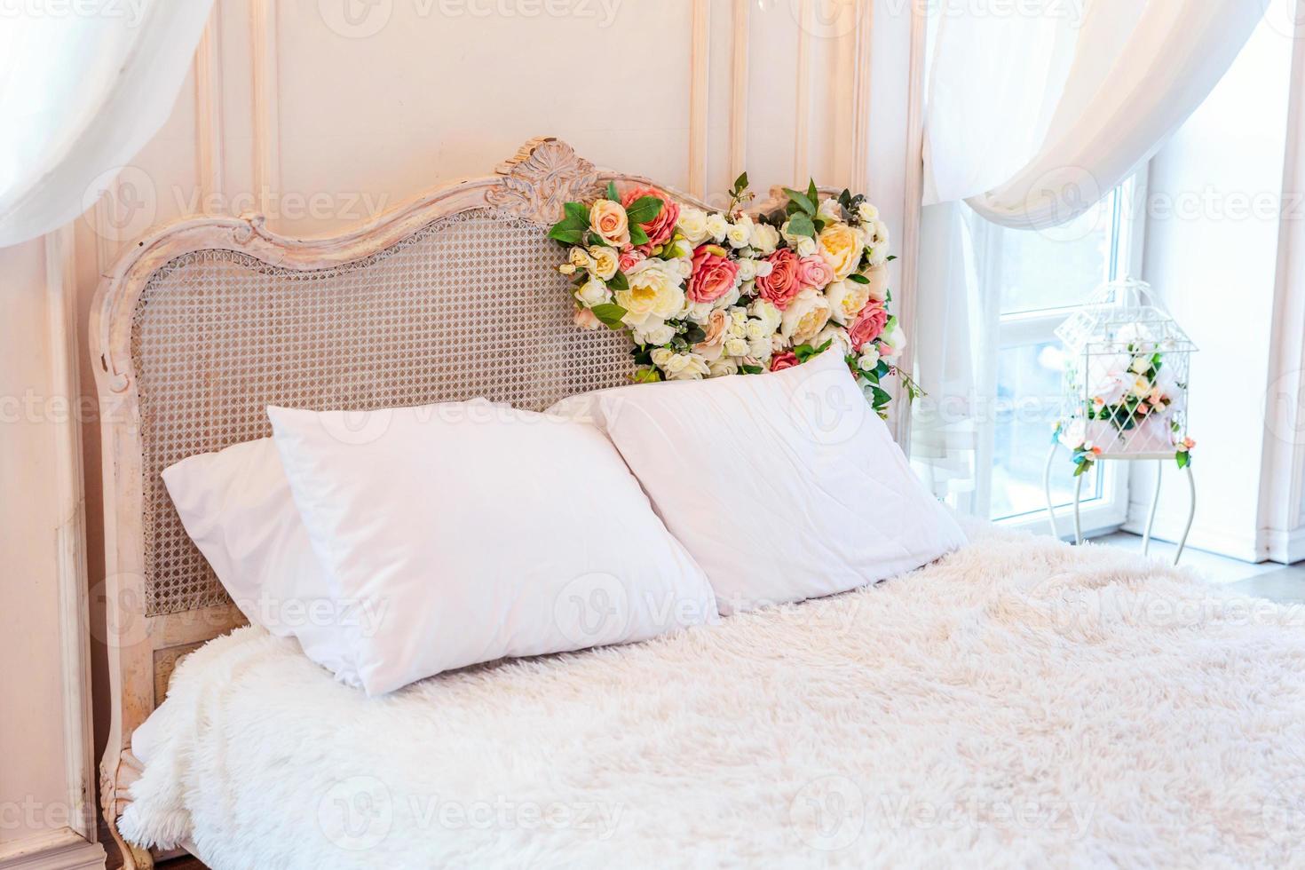 Beautiful luxury classic white bright clean interior bedroom in baroque style with king-size bed, large window, armchair and flower composition. photo