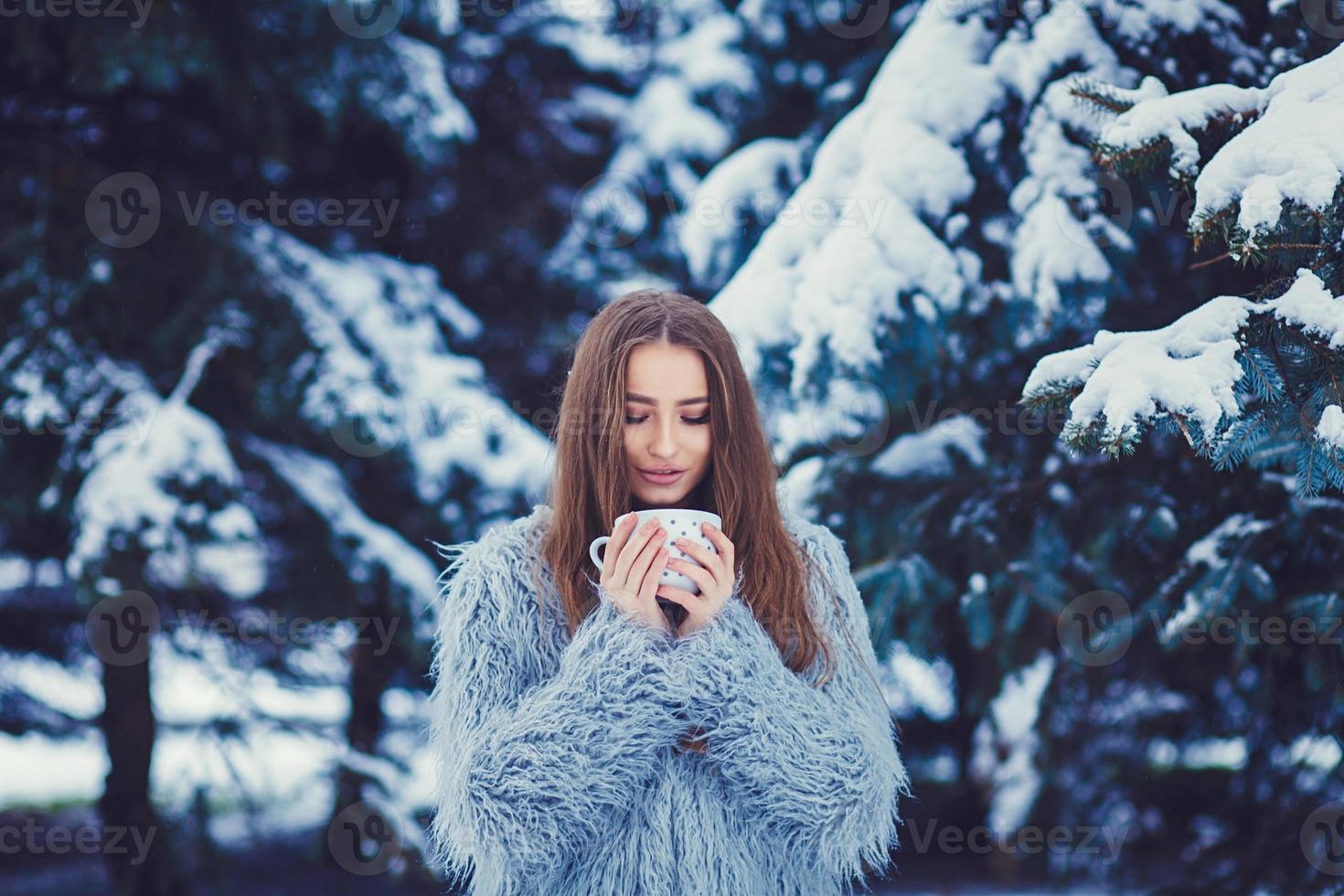 Girl in fur coat with a mug photo