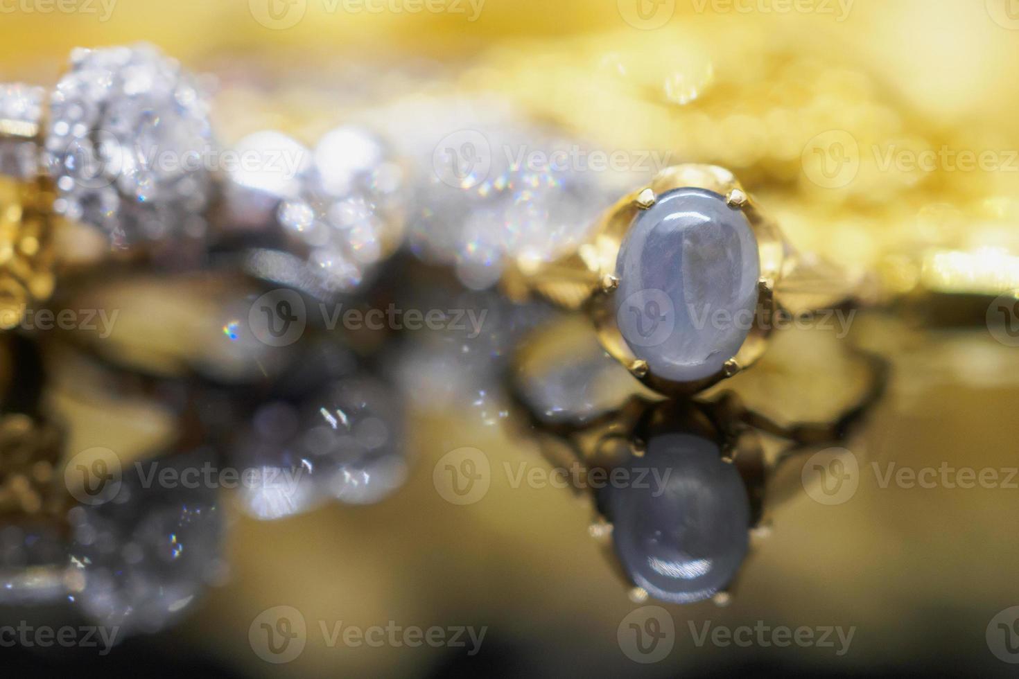 Vintage gold Jewelry blue sapphire rings with reflection on black background photo