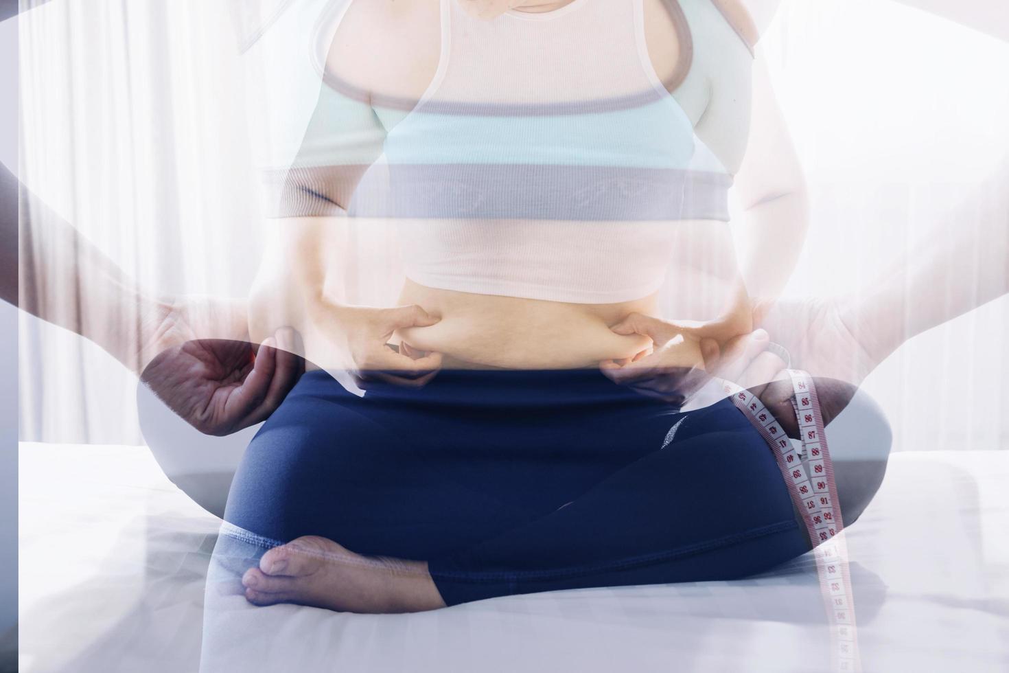 Beautiful fat woman with tape measure She uses her hand to squeeze the excess fat that is isolated on a white background. She wants to lose weight, the concept of surgery and break down fat under the photo