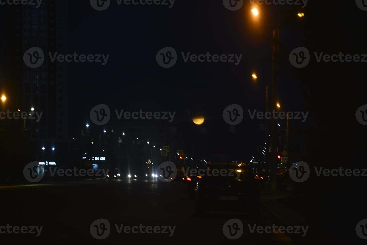 Multicolored reflections of lanterns on the evening road in the evening. Bluer and bokeh from the evening city. photo