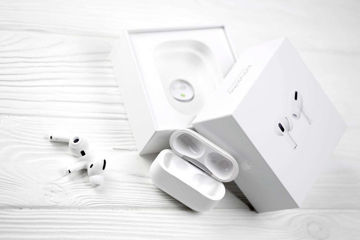 KHARKIV, UKRAINE - JANUARY 27, 2021 Apple AirPods Pro on a white background. Wireless headphones with charging case and a box. Apple Inc. is an American technology company photo