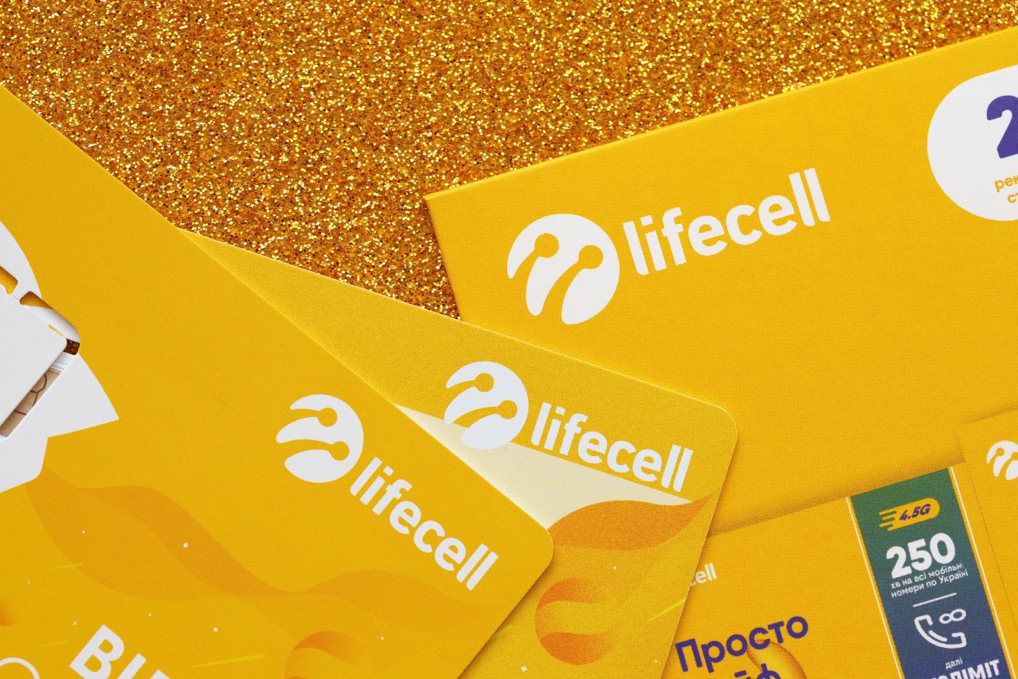 TERNOPIL, UKRAINE - JULY 5, 2022 Lifecell new sim card with free contract on yellow background. Lifecell is ukrainian mobile telephone network operator and provider of wireless connection photo
