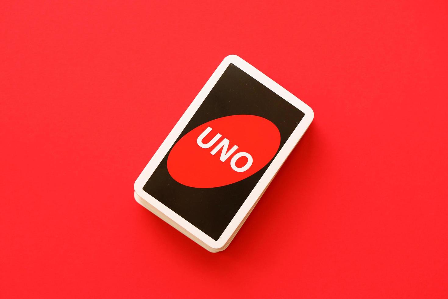 TERNOPIL, UKRAINE - MAY 15, 2022 Many colorful UNO game cards on red background. UNO is an American shedding-type card game that is played with a specially printed deck photo