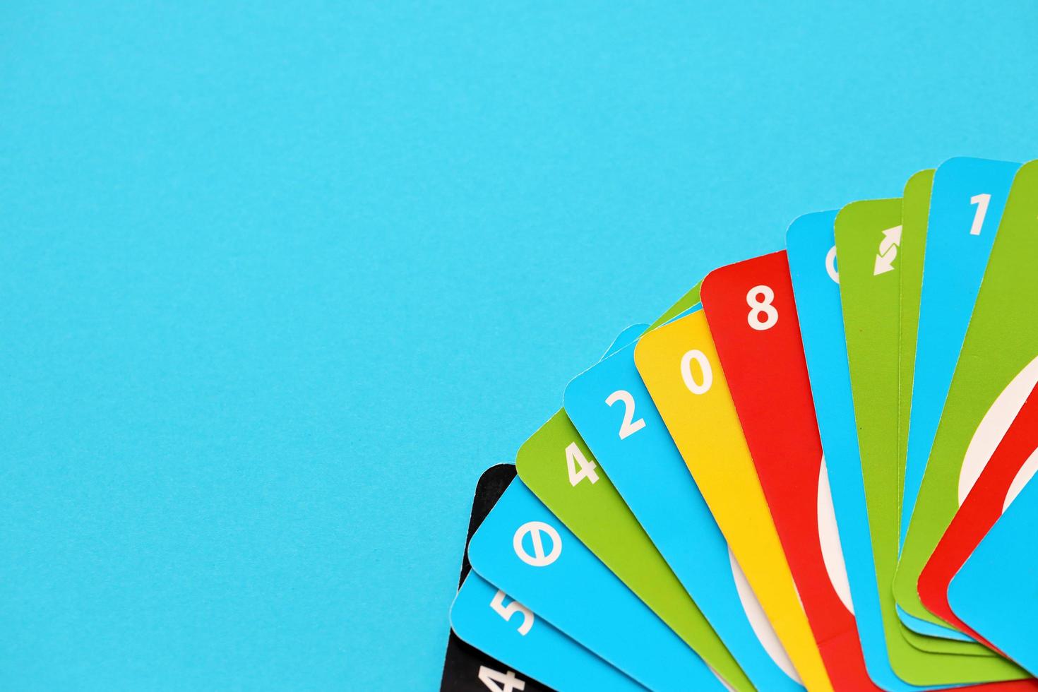TERNOPIL, UKRAINE - MAY 15, 2022 Many colorful UNO game cards on blue background. UNO is an American shedding-type card game that is played with a specially printed deck photo