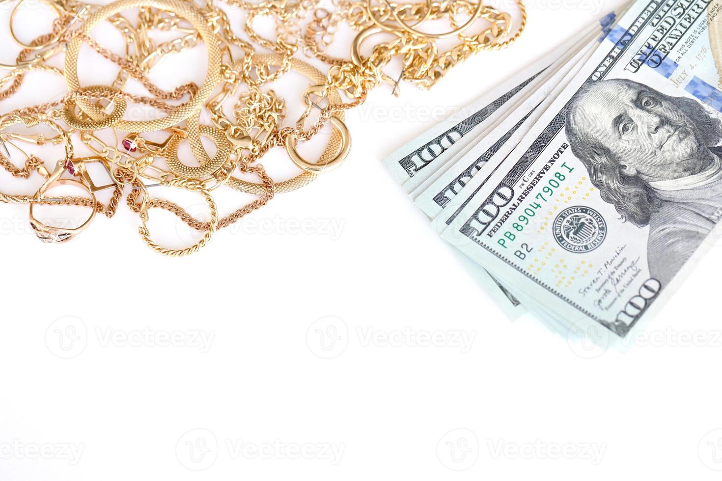 Many expensive golden jewerly rings, earrings and necklaces with big amount of US dollar bills on white background. Pawnshop or jewerly shop photo