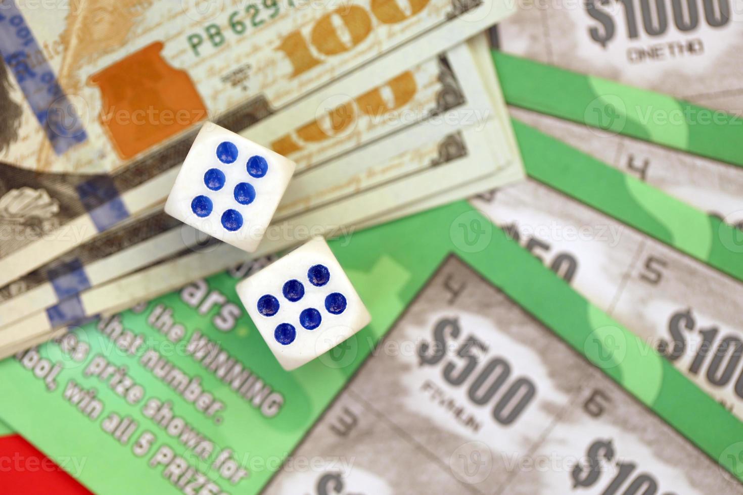 Close up view of green lottery scratch cards with us dollar bills and dice. Many used fake instant lottery tickets with gaming results photo