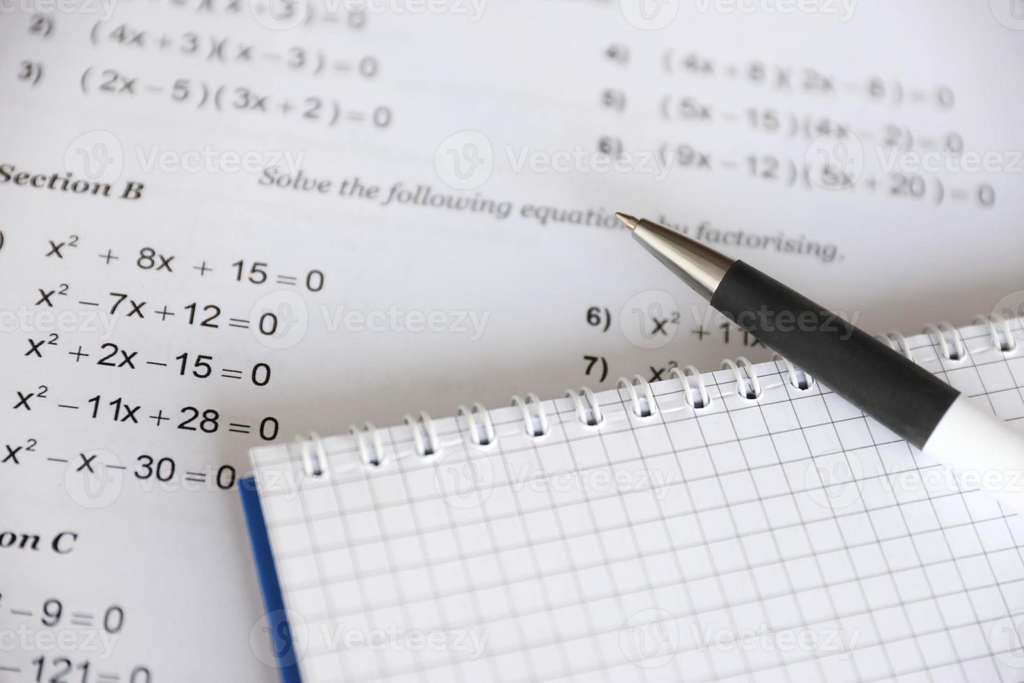 Handwriting of mathematics quadratic equation on examination, practice, quiz or test in maths class. Solving exponential equations concept. photo