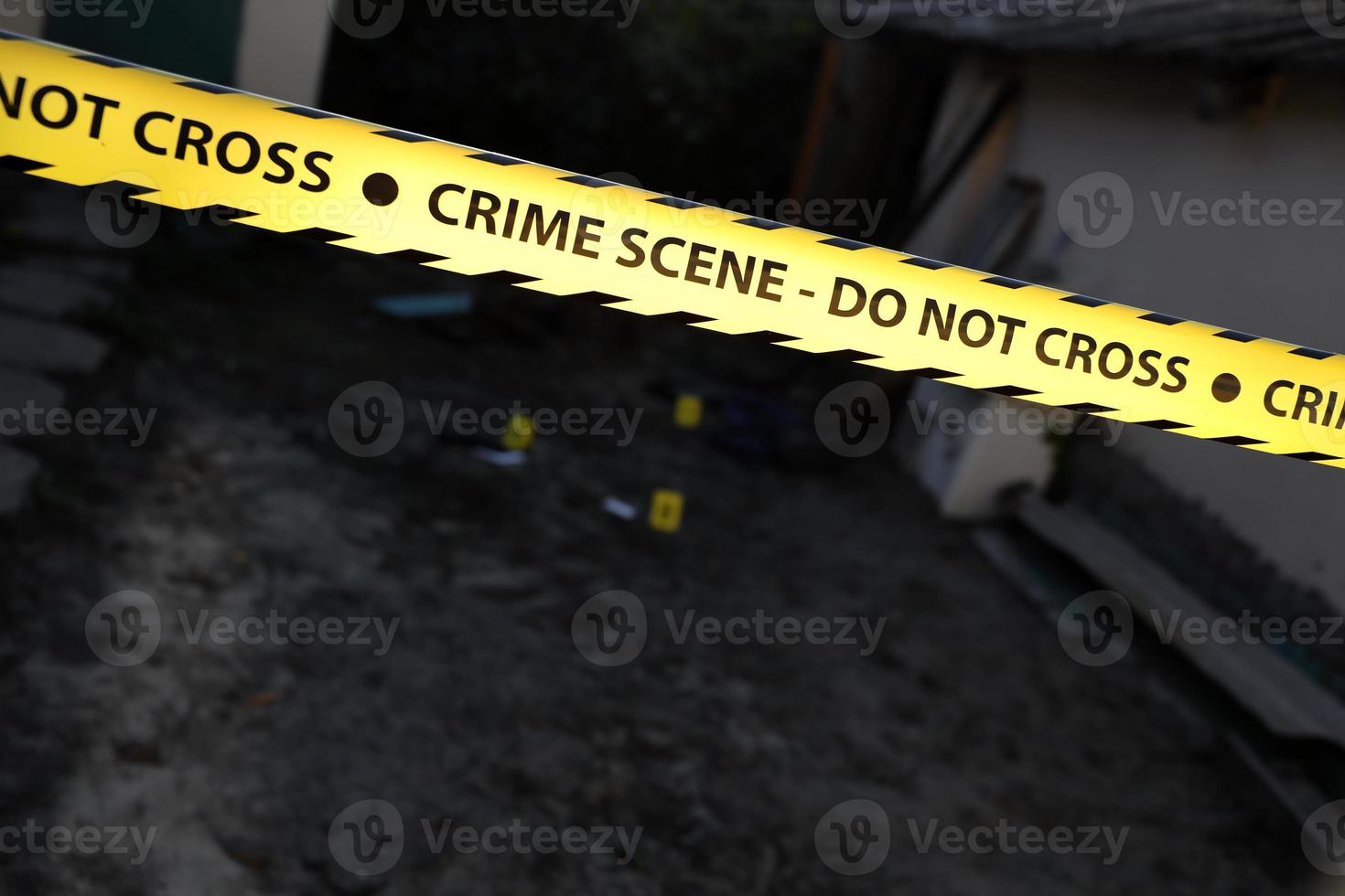 Crime scene tape for covering the area cordon. Yellow tape with blurred forensic law enforcement background in cinematic tone photo