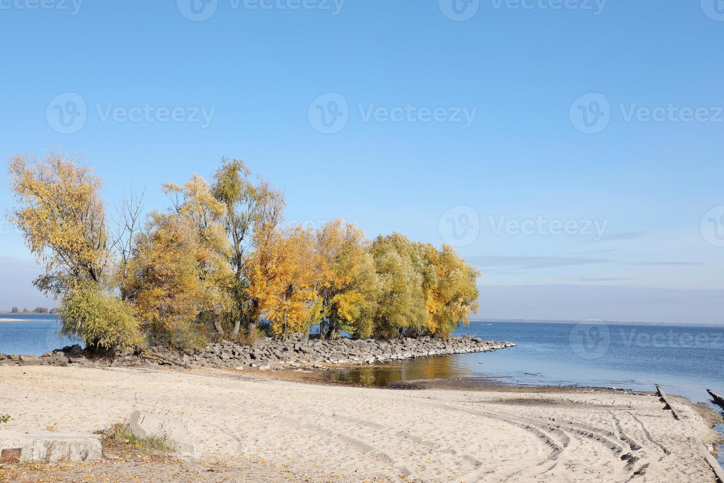 Beautiful autumn landscape with lake and multicoloral trees. Picturesque place with lake and tall trees photo