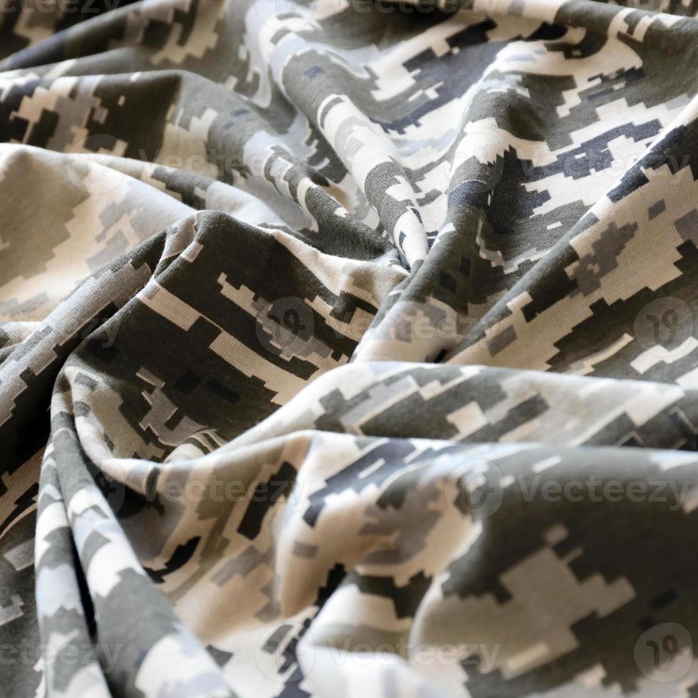 Fabric with texture of Ukrainian military pixeled camouflage. Cloth with camo pattern in grey, brown and green pixel shapes. Official uniform of Ukrainian soldiers photo