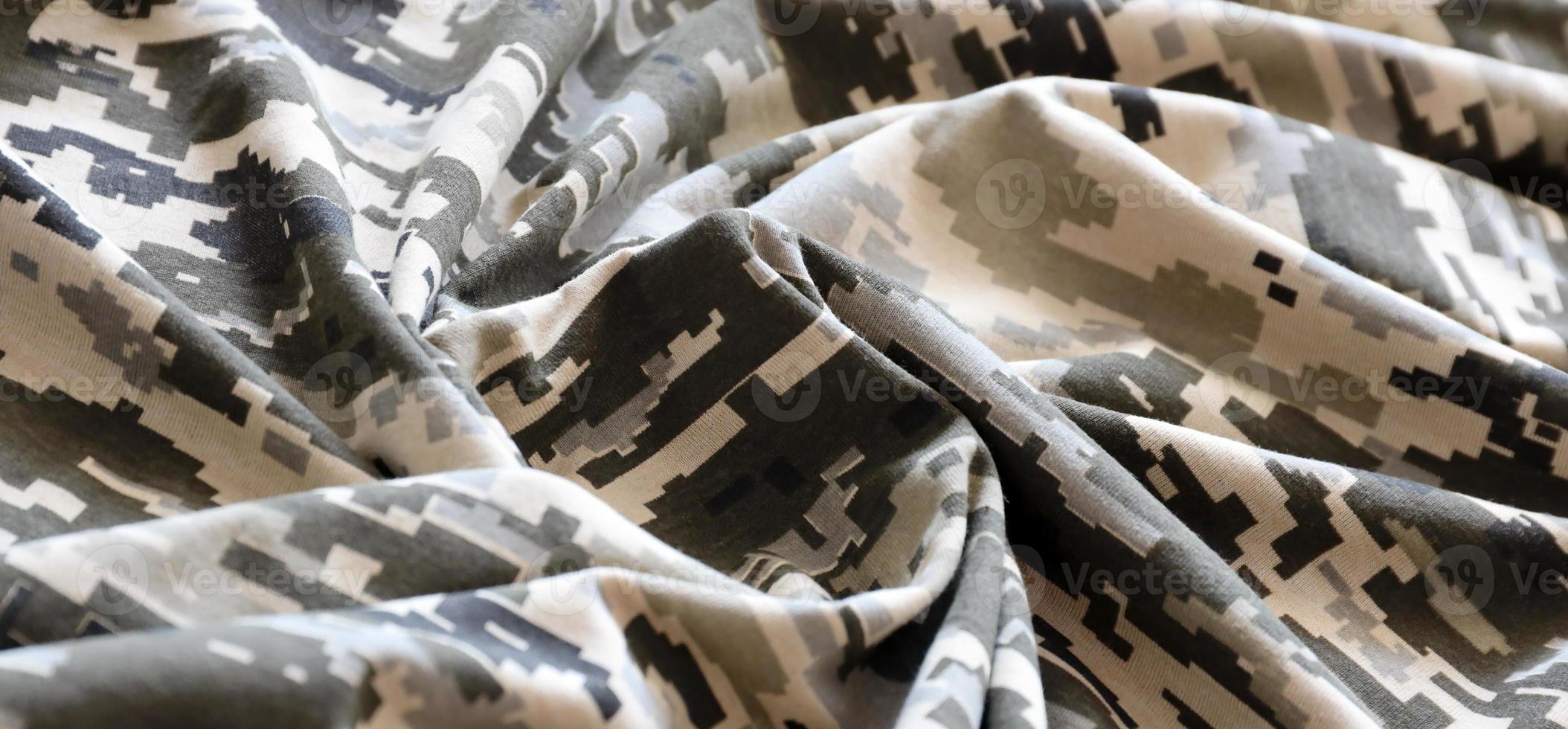 Fabric with texture of Ukrainian military pixeled camouflage. Cloth with camo pattern in grey, brown and green pixel shapes. Official uniform of Ukrainian soldiers photo