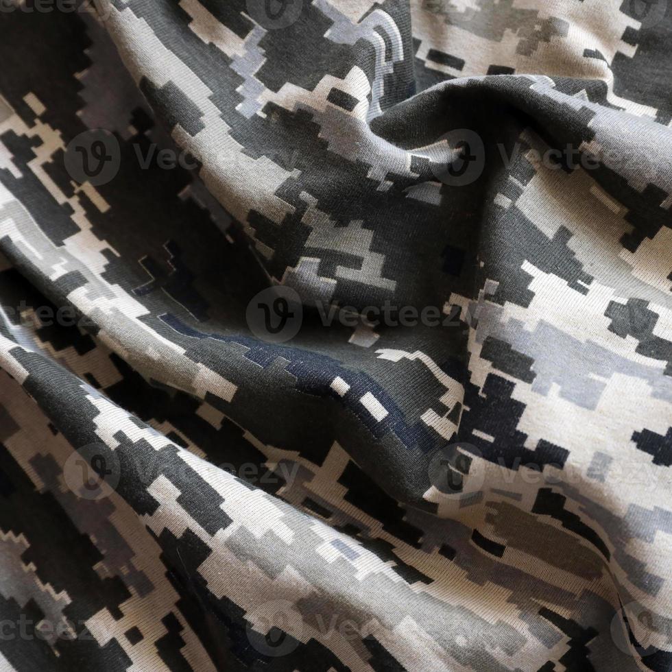 Fabric with texture of Ukrainian military pixeled camouflage. Cloth with camo pattern in grey, brown and green pixel shapes. Official uniform of Ukrainian soldiers photo