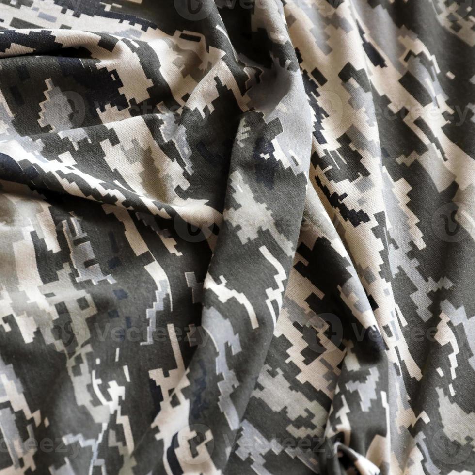 Fabric with texture of Ukrainian military pixeled camouflage. Cloth with camo pattern in grey, brown and green pixel shapes. Official uniform of Ukrainian soldiers photo