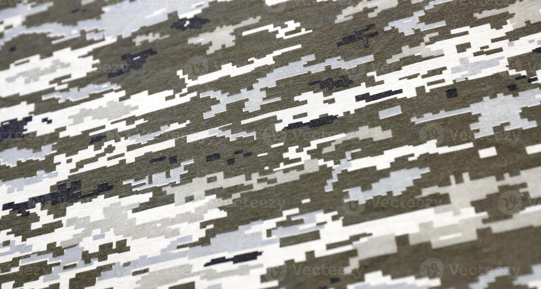 Fabric with texture of Ukrainian military pixeled camouflage. Cloth with camo pattern in grey, brown and green pixel shapes. Official uniform of Ukrainian soldiers photo