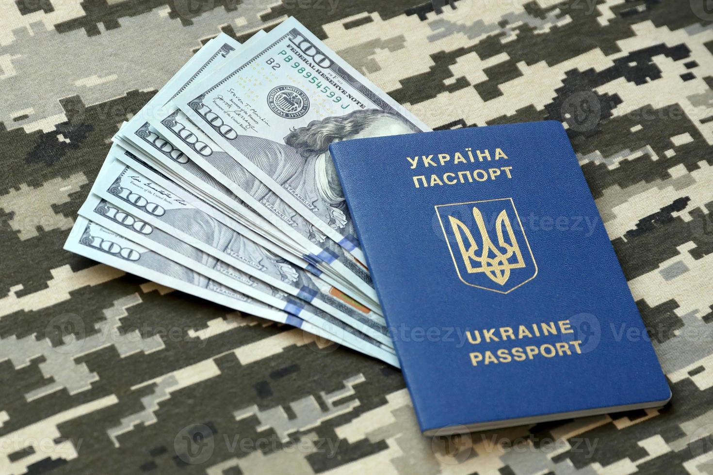 Ukrainian foreign passport on fabric with texture of military pixeled camouflage. Cloth with camo pattern in grey, brown and green pixel shapes and Ukrainian ID photo
