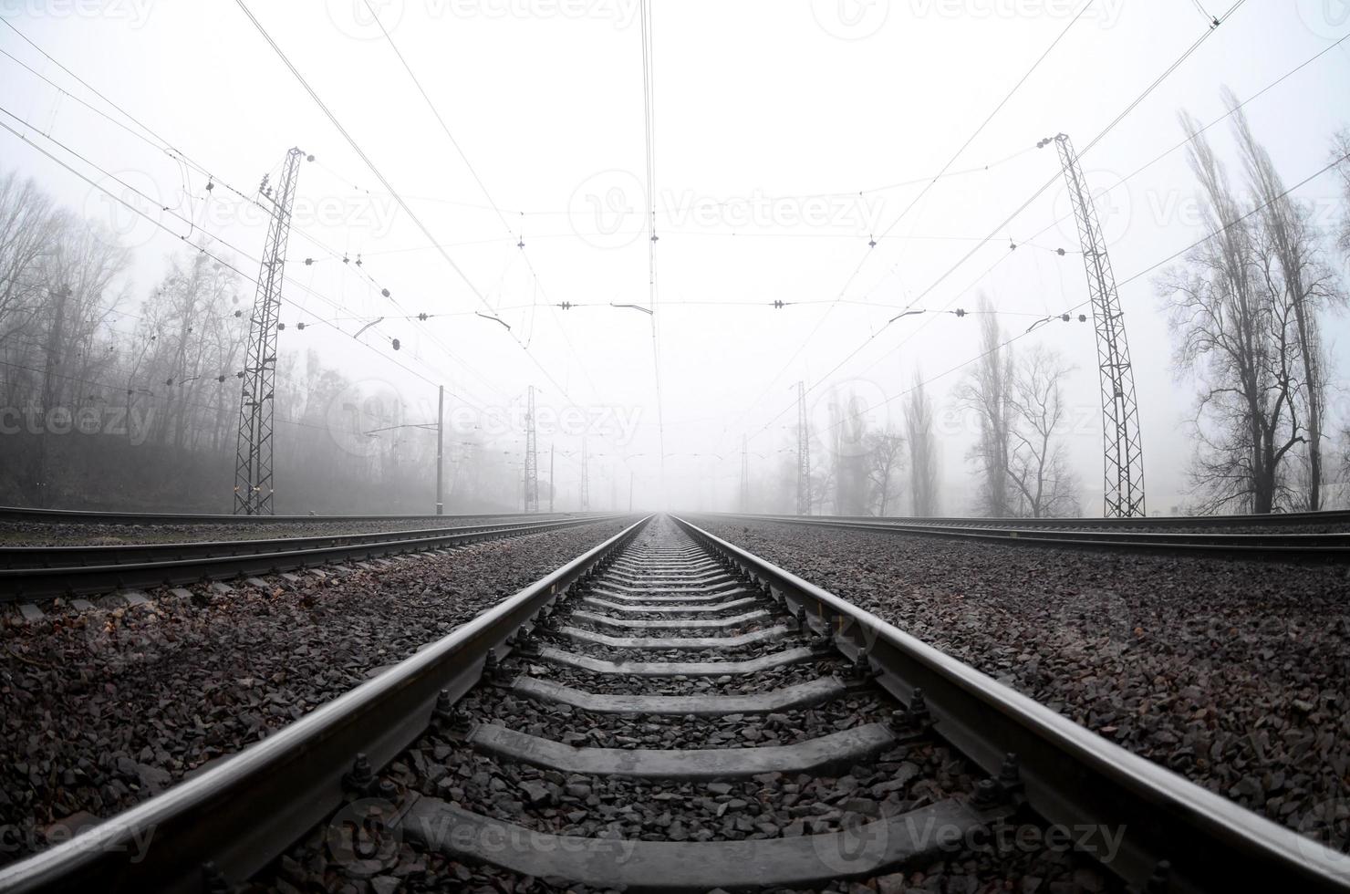 The railway track in a misty morning. A lot of rails and sleepers go into the misty horizon. Fisheye photo with increased distortion