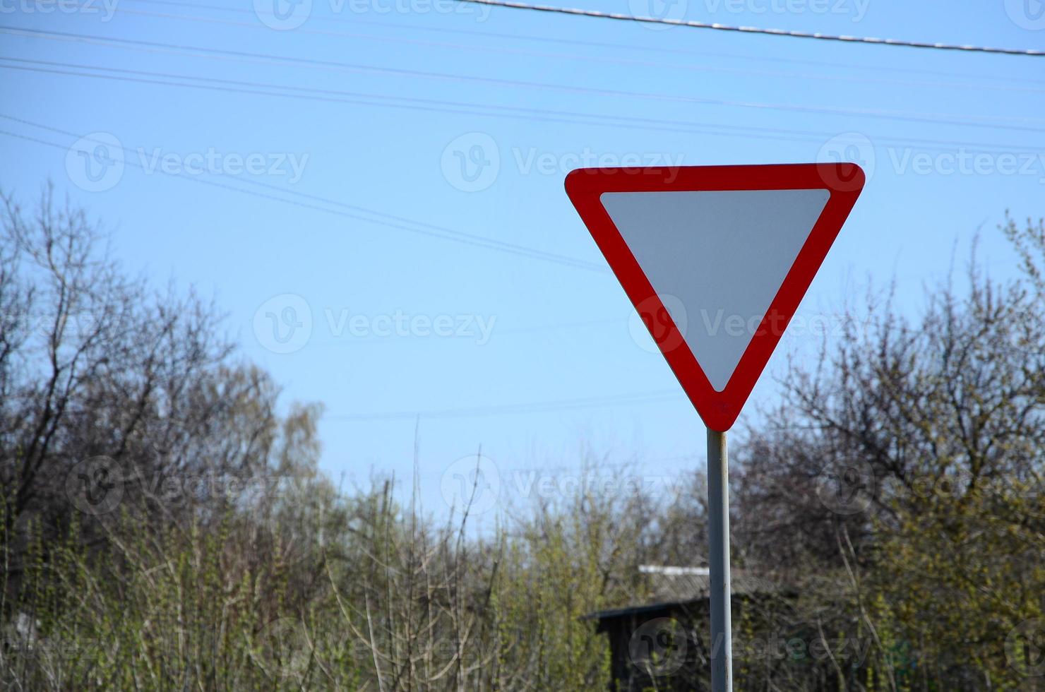 Traffic sign in the form of a white triangle. Give way photo