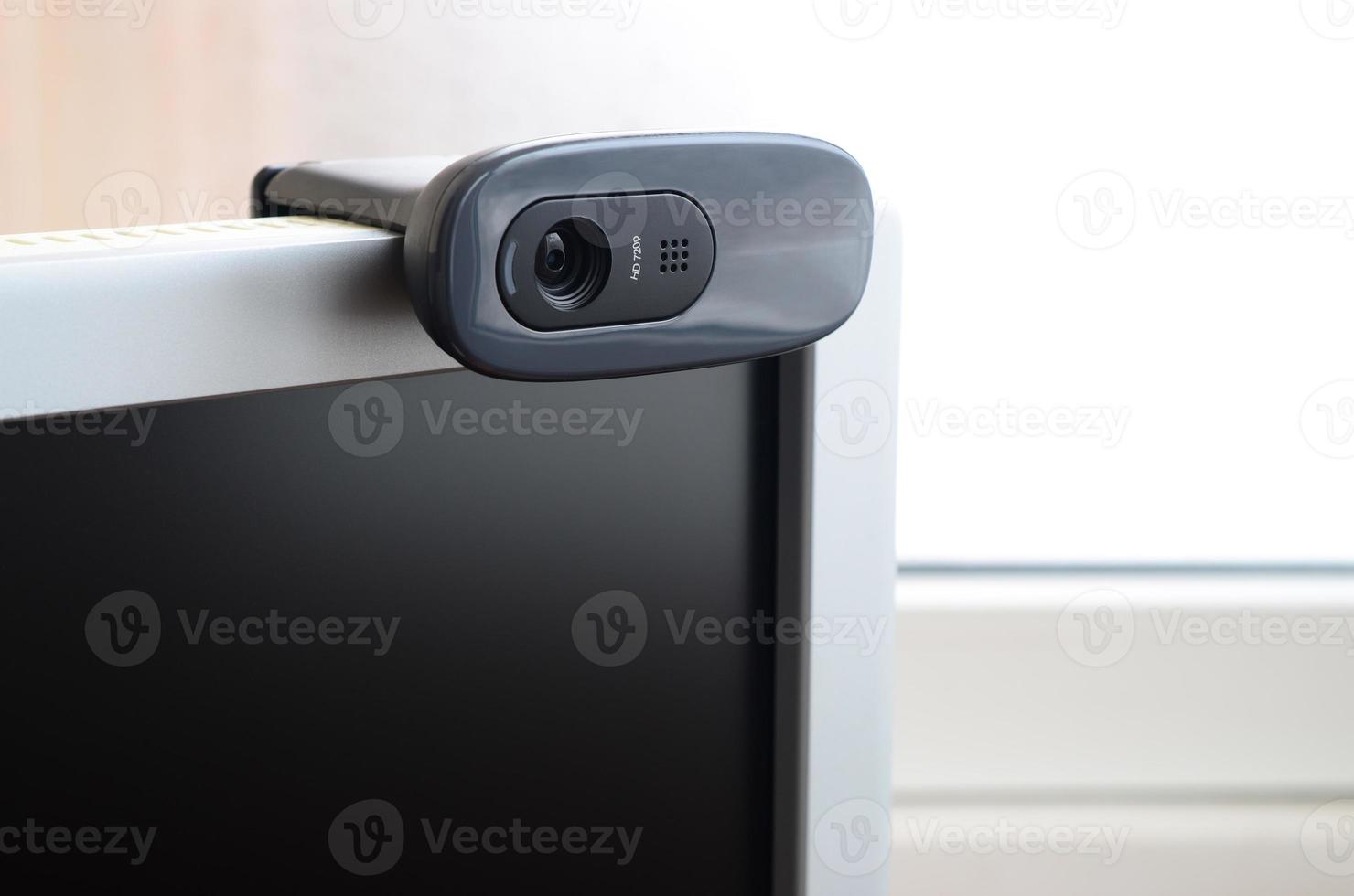 A modern web camera is installed on the body of a flat screen monitor. Device for video communication and recording of high quality video photo