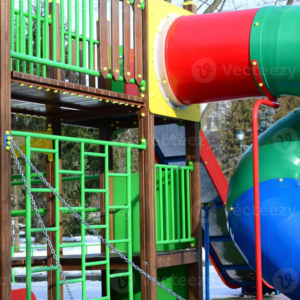 Fragment of a playground made of plastic and wood, painted in different colors photo