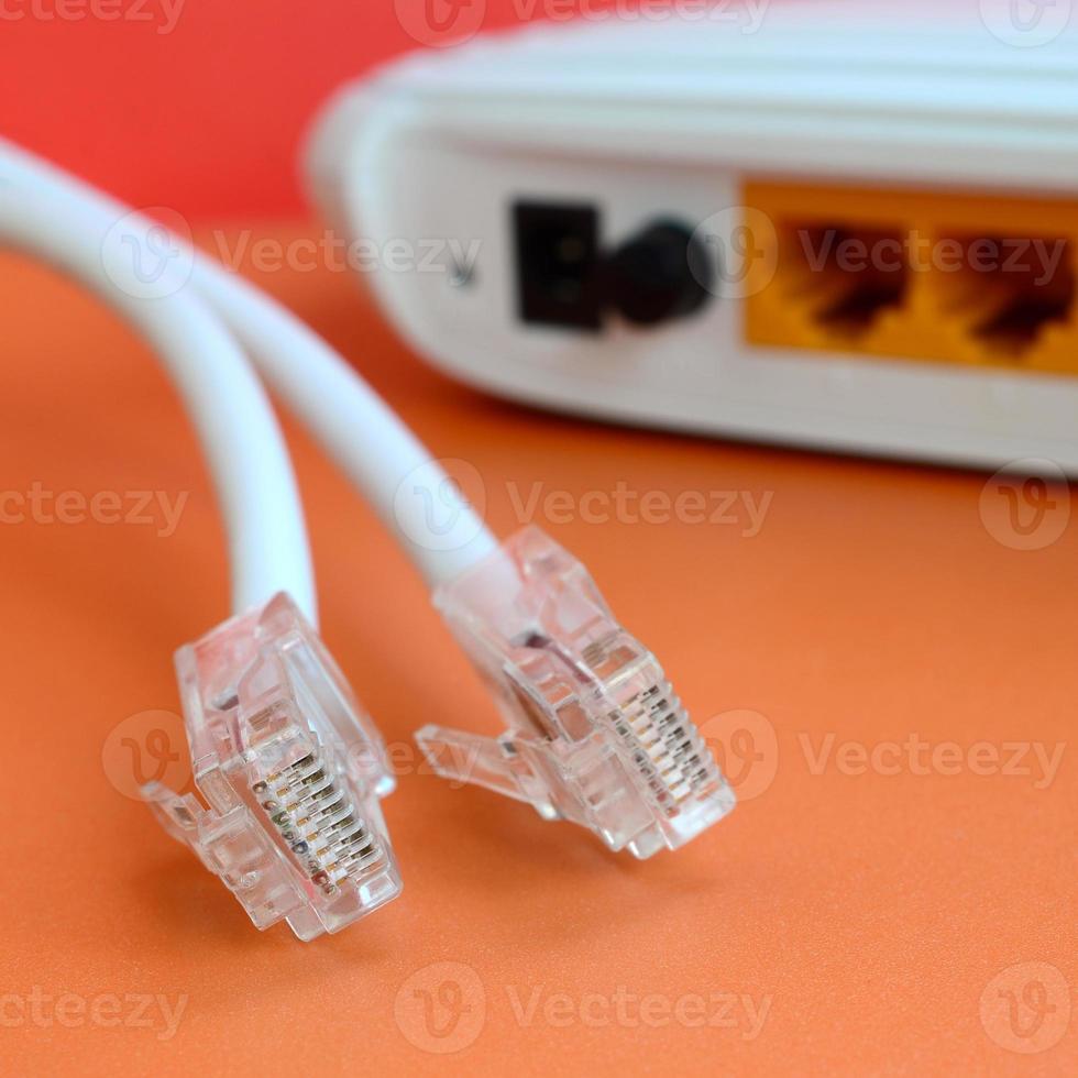 Internet router and Internet cable plugs lie on a bright orange background. Items required for Internet connection photo