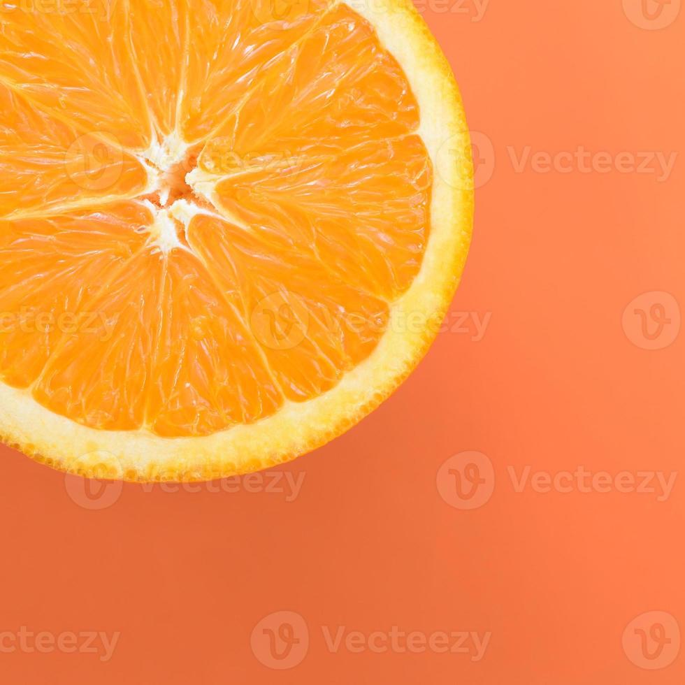 Top view of a one orange fruit slice on bright background in orange color. A saturated citrus texture image photo