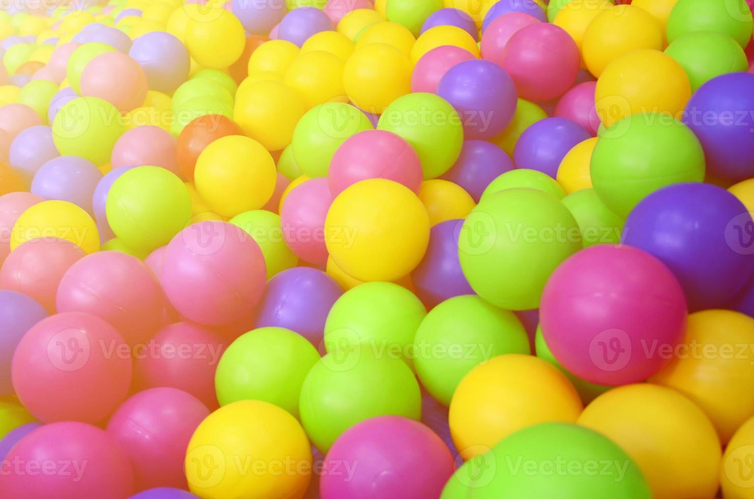 Many colorful plastic balls in a kids' ballpit at a playground. Close up pattern photo