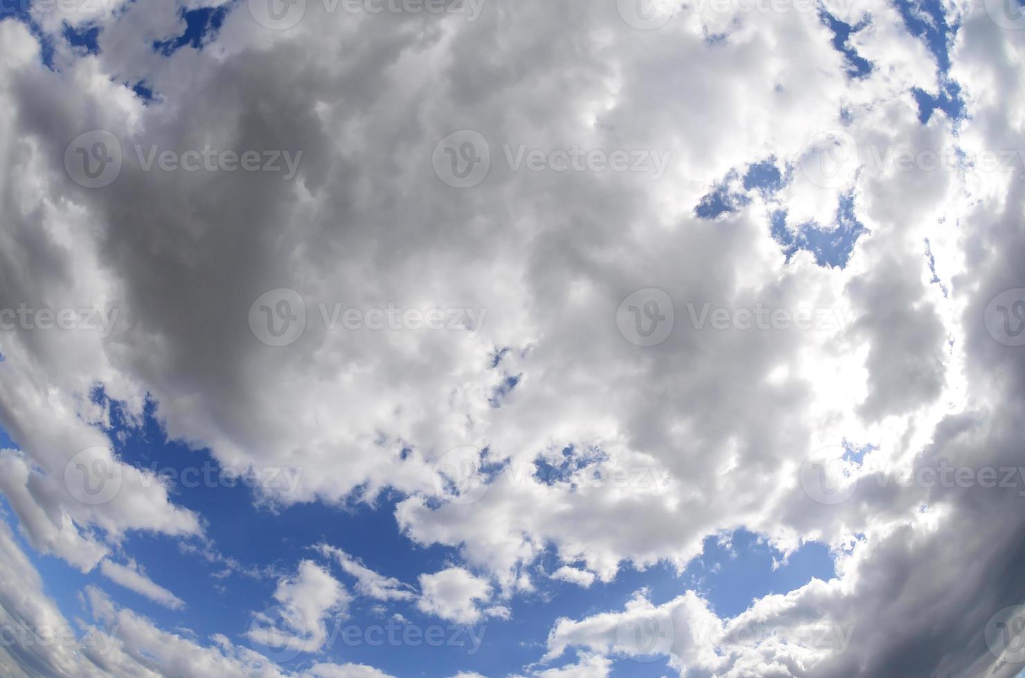 A blue sky with lots of white clouds of different sizes. Fisheye photo