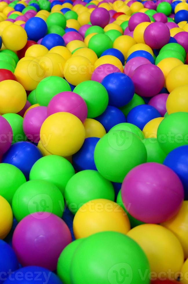Many colorful plastic balls in a kids' ballpit at a playground. Close up pattern photo
