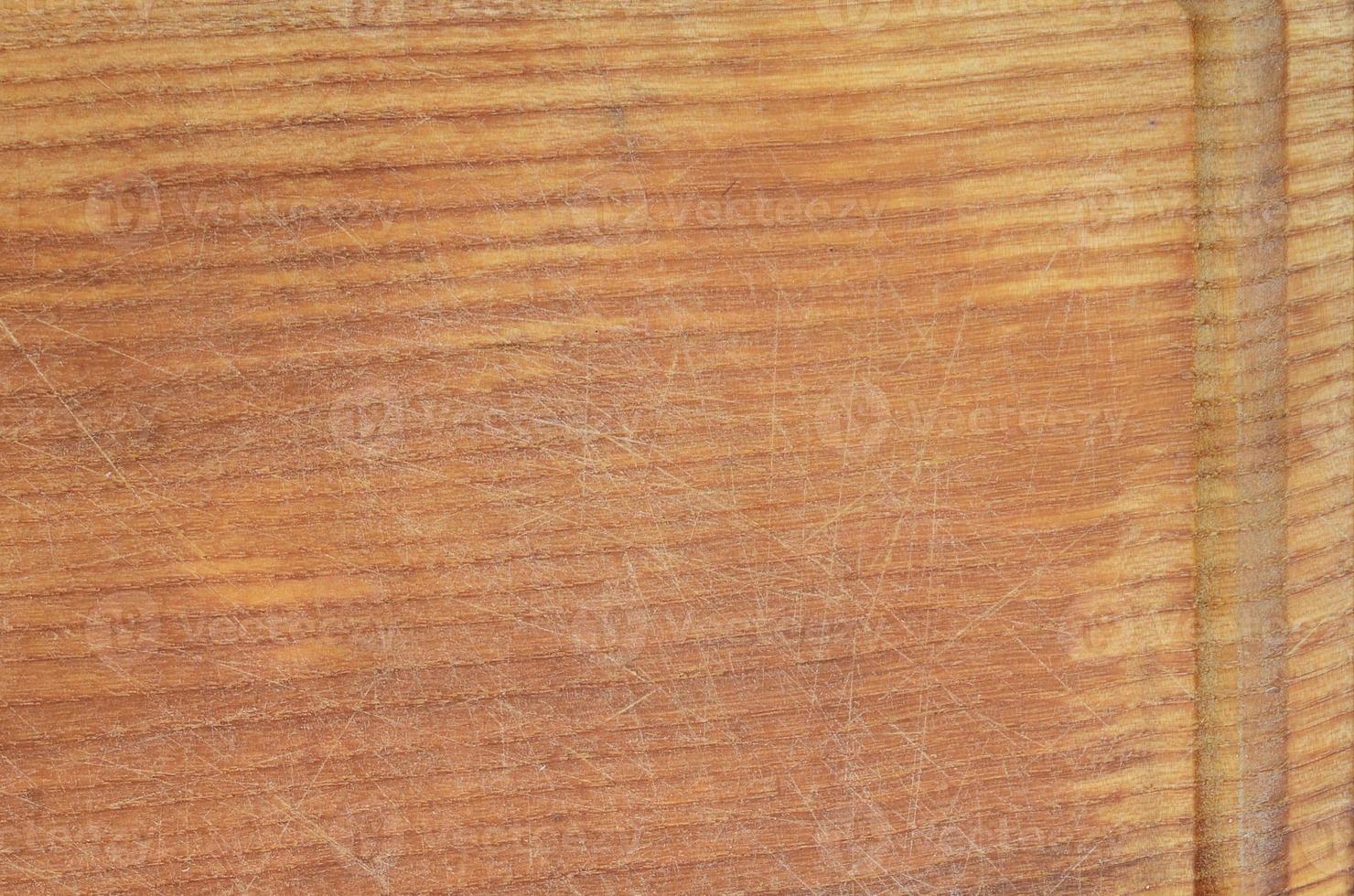 Detailed texture of the wooden cutting board with a lot of scars from the ax and knife photo
