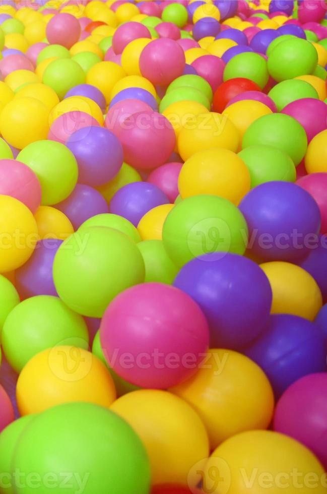 Many colorful plastic balls in a kids' ballpit at a playground. Close up pattern photo