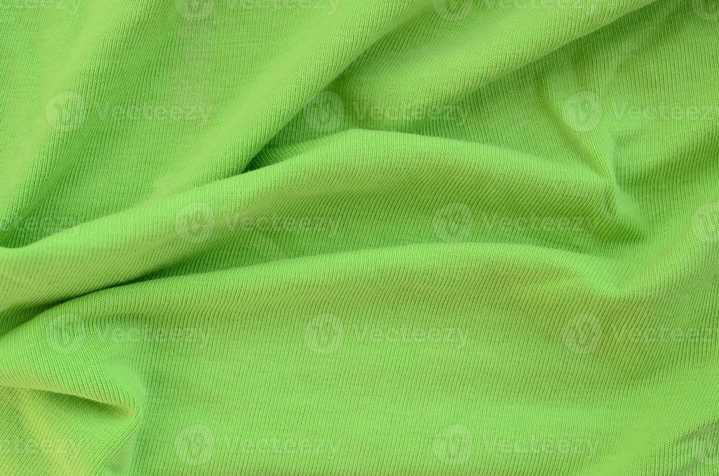 The texture of the fabric is bright green. Material for making shirts and blouses photo
