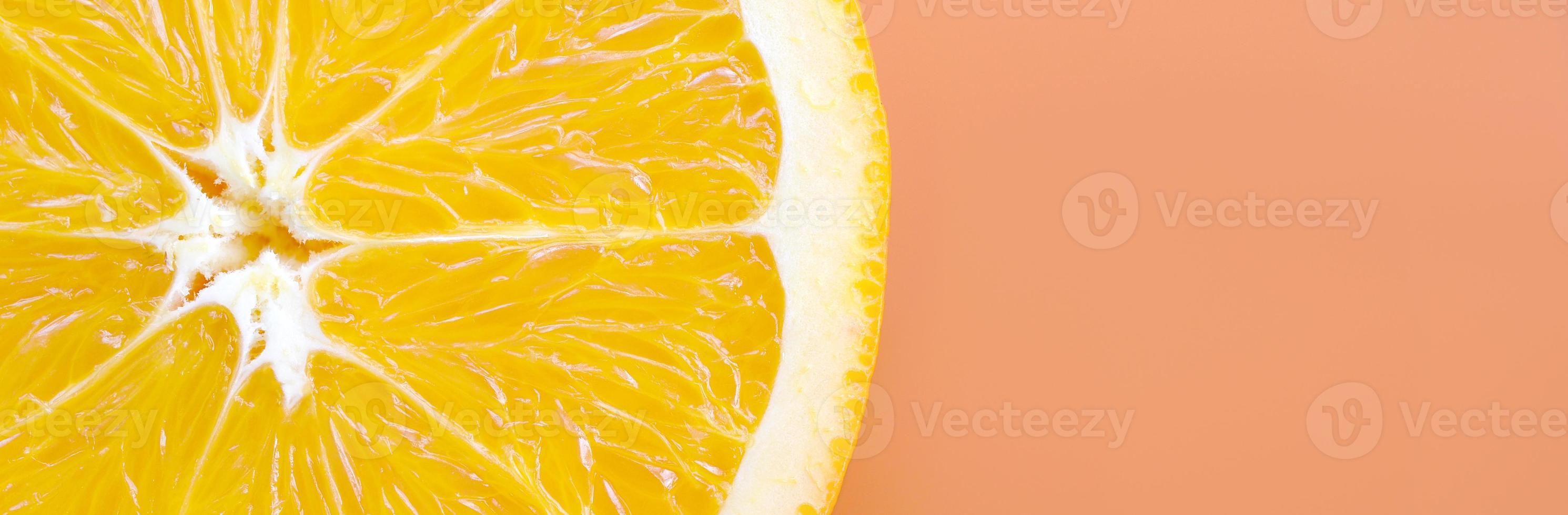 Top view of a one orange fruit slice on bright background in orange color. A saturated citrus texture image photo