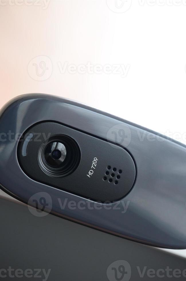 A modern web camera is installed on the body of a flat screen monitor. Device for video communication and recording of high quality video photo