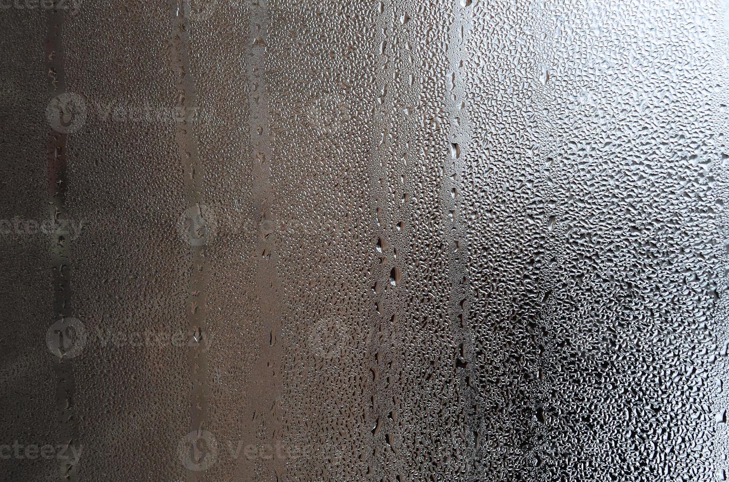 Texture of a drop of rain on a glass wet transparent background. Toned in grey color photo