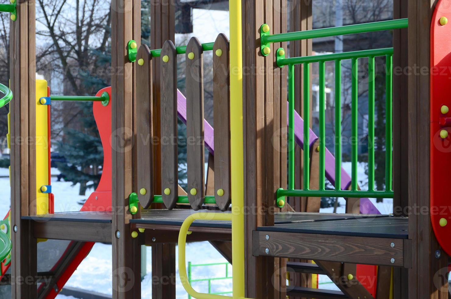 Fragment of a playground made of plastic and wood, painted in different colors photo