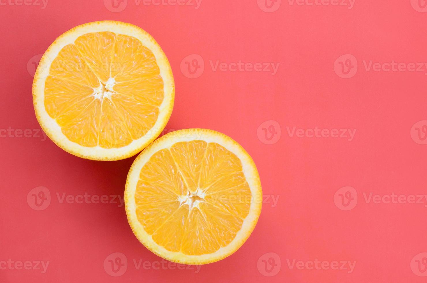 Top view of a several orange fruit slices on bright background in red color. A saturated citrus texture image photo